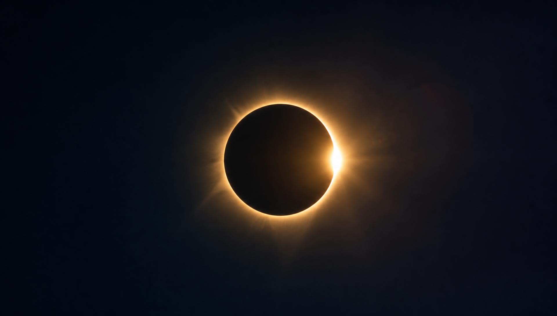 Eclipse solar total com coroa dourada num céu escuro